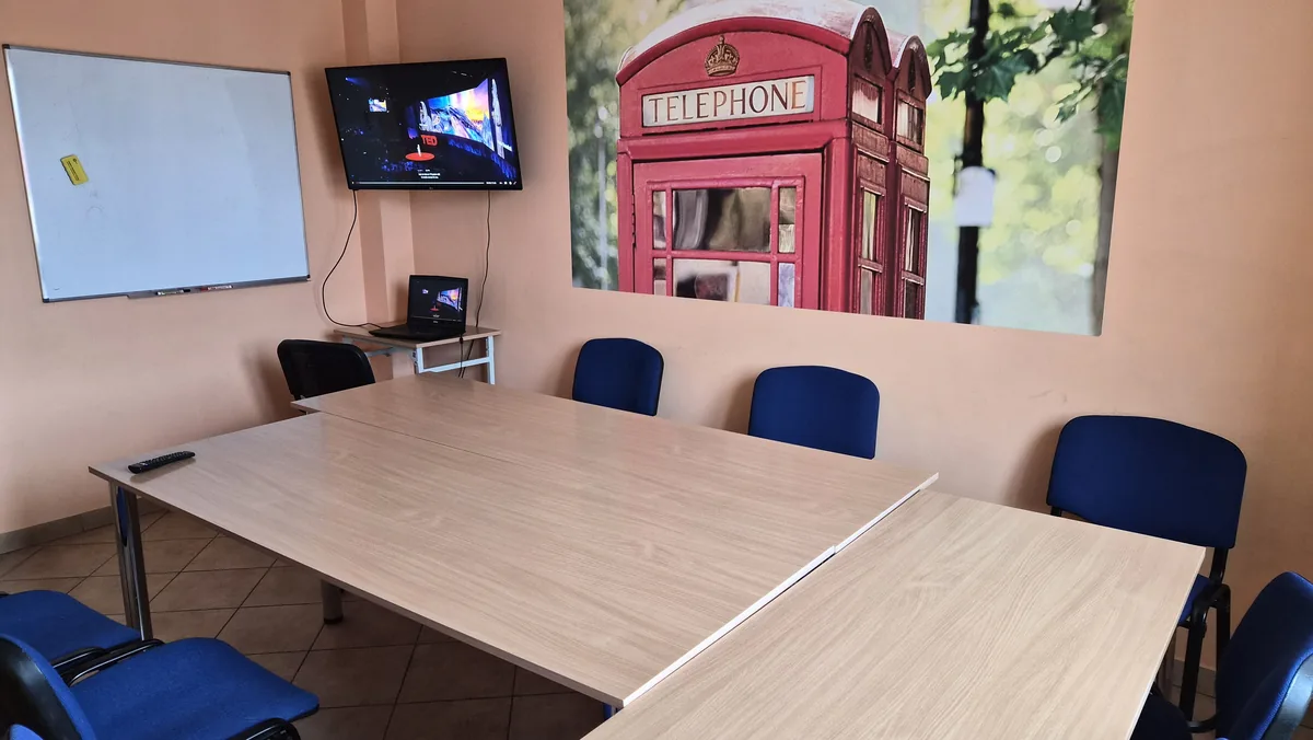 Sala kameralna dla 8–10 osób z telewizorem, tablicą suchościeralną i fototapetą z londyńską budką telefoniczną